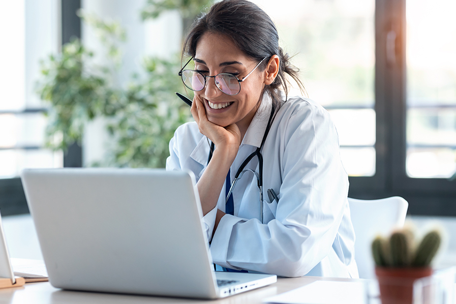 doctor on laptop smiling